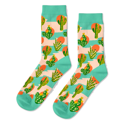 Pair of crew socks with a desert theme. Features green saguaro and prickly pear cacti, orange suns, on a peach-pink and mint green striped background.
