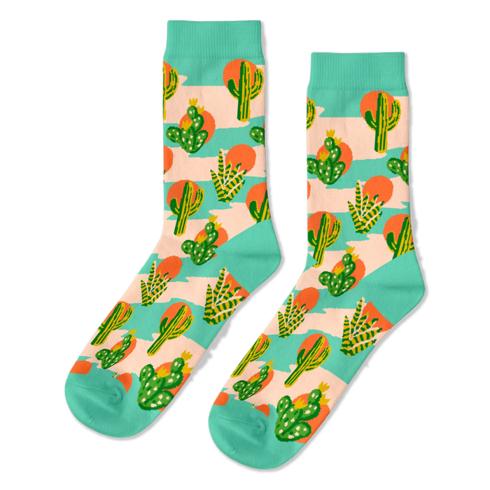 Pair of crew socks with a desert theme. Features green saguaro and prickly pear cacti, orange suns, on a peach-pink and mint green striped background. }}