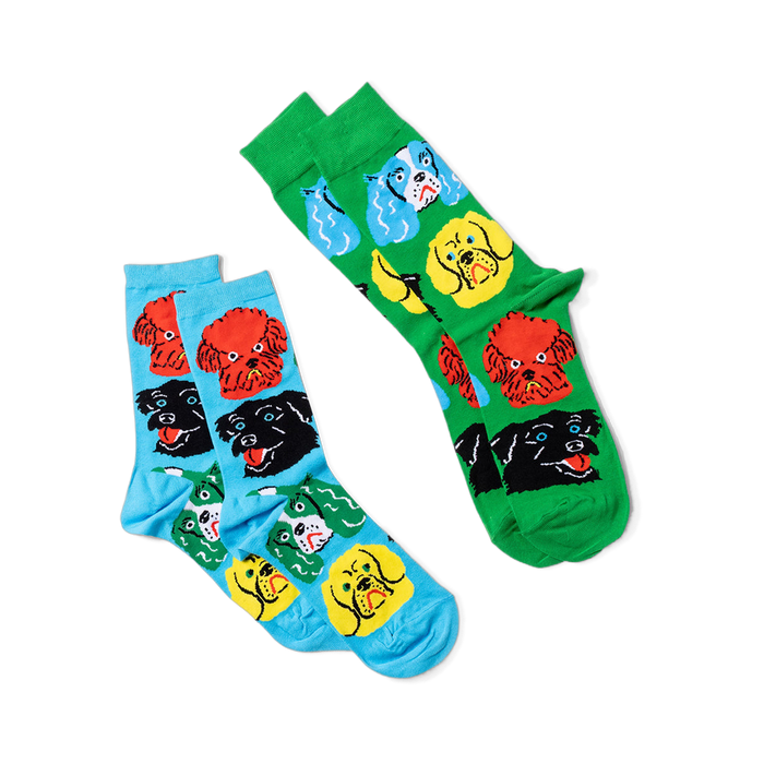 Two pairs of crew socks: one green with colorful dog faces, one light blue with colorful dog faces.