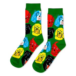 A pair of bright green crew socks featuring a repeating pattern of colorful cartoon dog faces in red, yellow, black, and blue.