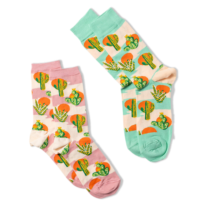 Two pairs of crew socks with Southwest cactus patterns. One pair features lavender accents, the other has blue-green accents.