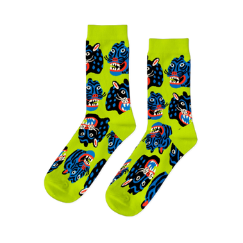 Pair of crew socks with a repeating pattern of stylized black and blue wild cat faces, snarling, on a neon lime green background.