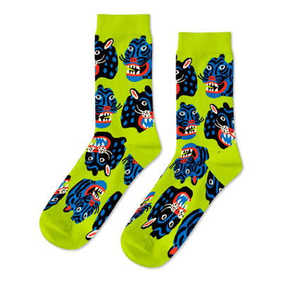Pair of crew socks with a repeating pattern of stylized black and blue wild cat faces, snarling, on a neon lime green background.