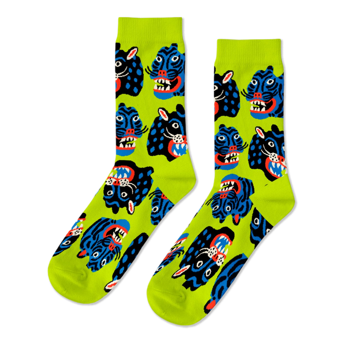 Pair of crew socks with a repeating pattern of stylized black and blue wild cat faces, snarling, on a neon lime green background. }}
