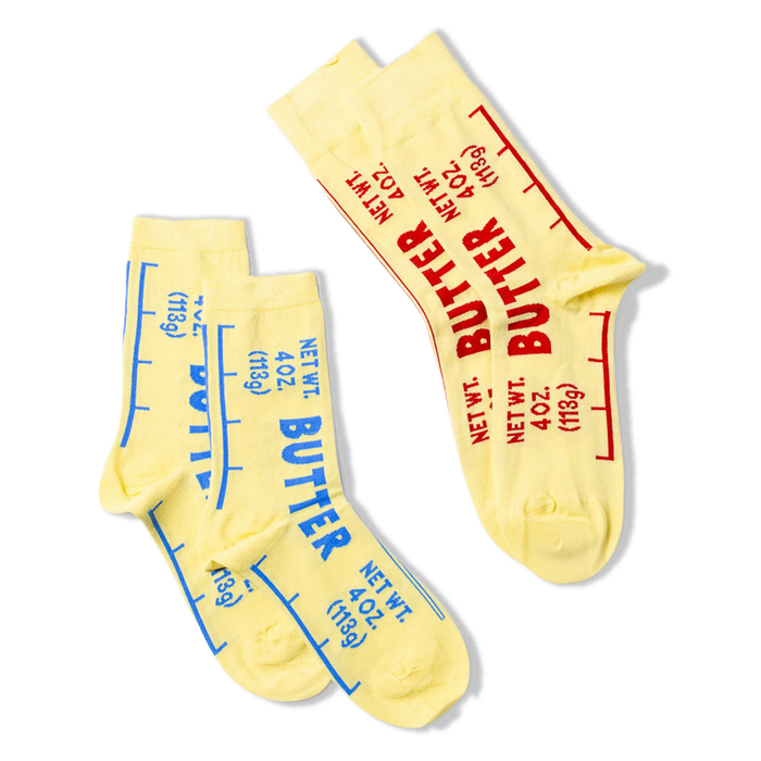 Two yellow crew socks, one pair with blue 'BUTTER' text, and a single sock with red 'BUTTER' text, displayed together.