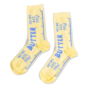 Pair of yellow crew socks designed like butter sticks, featuring blue 'BUTTER' text and net weight measurements.