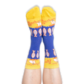 Person wearing blue and yellow anchovy socks with their feet pointed up against a black background, showing the toe design.