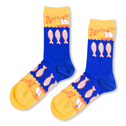 Royal blue crew socks with an anchovy pattern, featuring bright yellow toes and cuffs with retro orange text and sailboats.