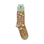 A lifestyle shot showing the socks on a person's feet. The socks have a light brown base with coffee-themed illustrations and text.