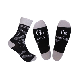 black & gray crew socks with a book pattern and the words "go away...i'm i'm reading" on the sole   