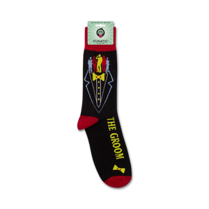 A pair of black socks with a tuxedo printed on them. The tuxedo has a yellow bow tie and a red pocket square. The words 