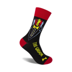 Black crew socks with a red cuff, featuring a tuxedo graphic and colorful groomsmen figures. Text reads 'The Groom'.