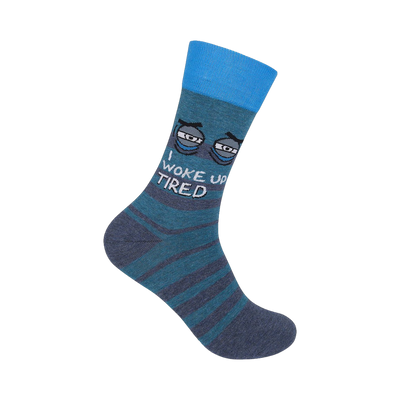 Crew socks in teal and grey featuring a pair of cartoon eyes and the text 'I Woke Up Tired'.