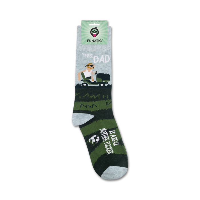 A pair of green and gray socks with the image of a man mowing a lawn on one sock and the words 