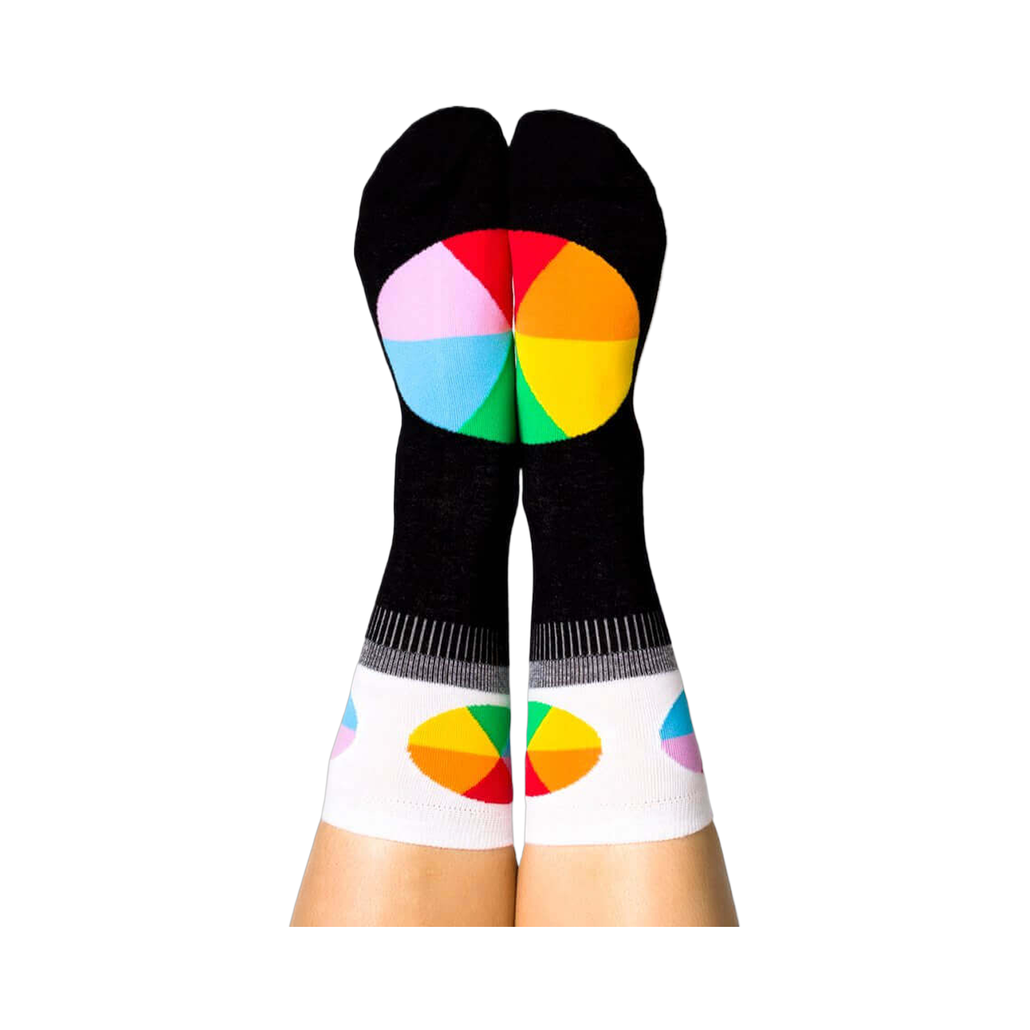 A person's legs with feet up, wearing the black Color Wheel crew socks. The heels show large color wheels, cuffs have smaller ones.
