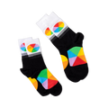 Two pairs of black crew socks with white cuffs and color wheel designs, lying flat and angled differently on a black background.