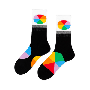 Pair of black crew socks with white cuffs featuring oval color wheel designs. Additional color wheel segments visible on the feet.