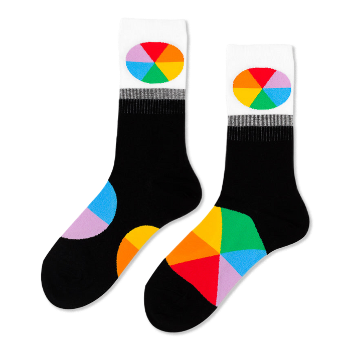 Pair of black crew socks with white cuffs featuring oval color wheel designs. Additional color wheel segments visible on the feet.