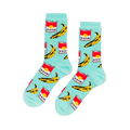 A pair of light blue crew socks with a repeating pop art pattern of red soup cans and yellow bananas, laid flat against a black background.