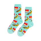 A pair of light blue crew socks with a repeating pop art pattern of red soup cans and yellow bananas, laid flat against a black background.