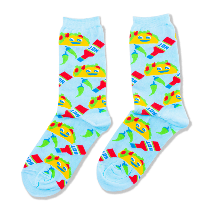A pair of light blue crew socks covered in a pattern of yellow smiling tacos, red hot sauce bottles, and green chili peppers. }}