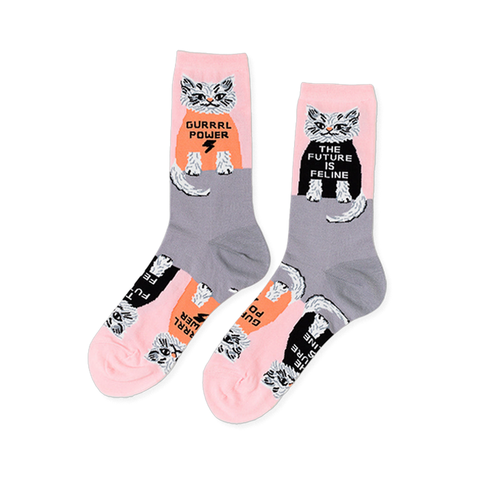 Pair of crew socks in pink and grey, patterned with white cats wearing black and orange shirts with 
