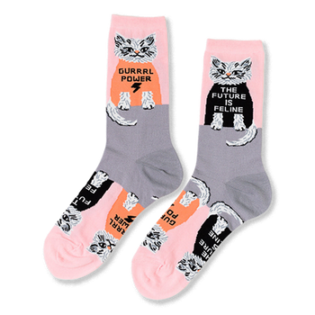 Pair of crew socks in pink and grey, patterned with white cats wearing black and orange shirts with "GURRRL POWER" and "THE FUTURE IS FELINE".