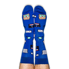 Pair of legs pointing up wearing blue socks covered in retro computer icons including a smiling monitor and floppy disk.