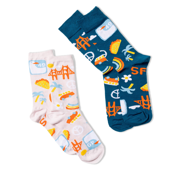 Two pairs of crew socks, one dark blue and one light pink, both with San Francisco themed patterns visible.