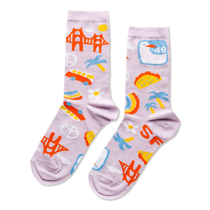 A pair of lavender crew socks with a San Francisco theme, featuring the Golden Gate Bridge, cars, tacos, peace signs, and 'SF' letters.