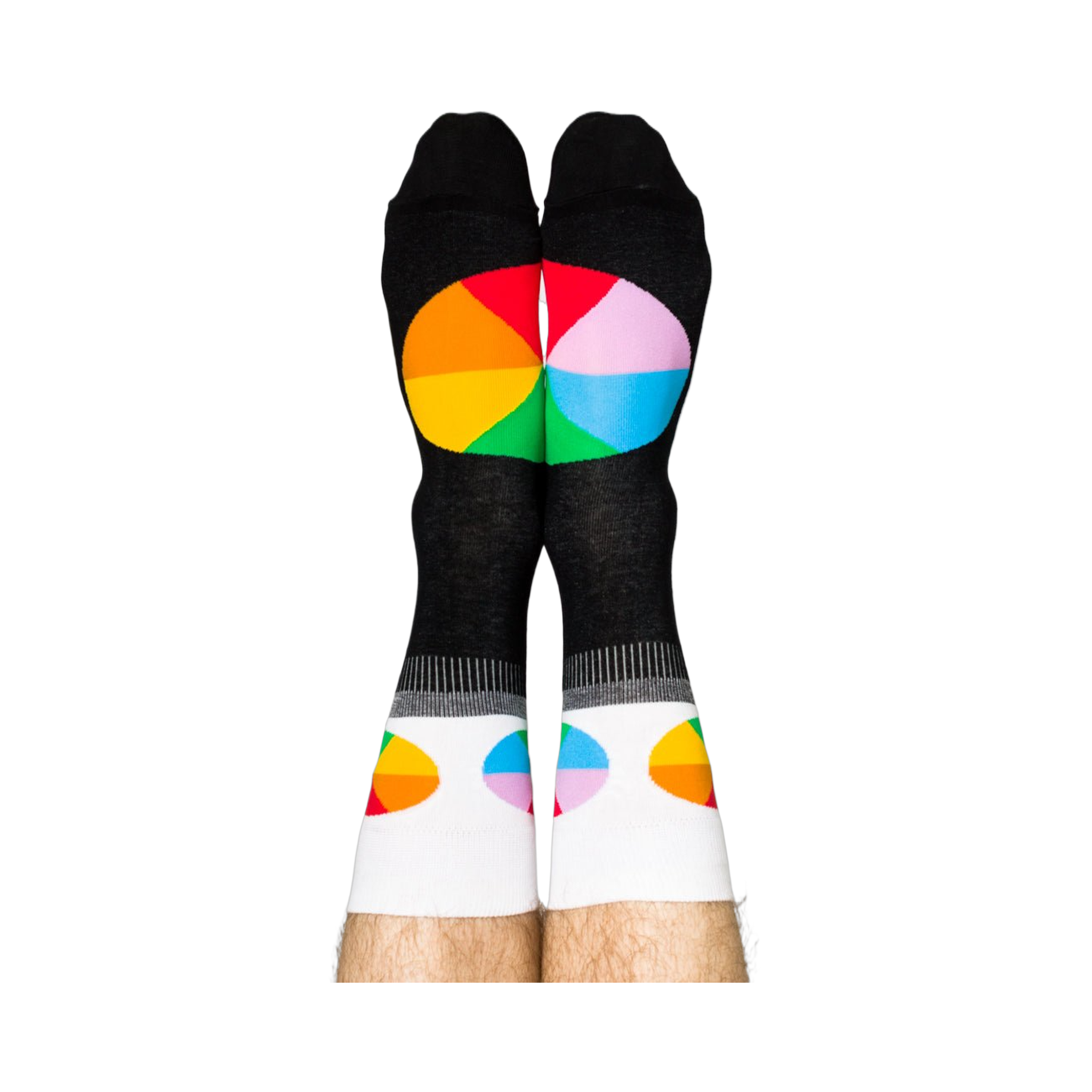 Person standing, wearing black crew socks with white cuffs and colorful, segmented color wheel designs on feet.