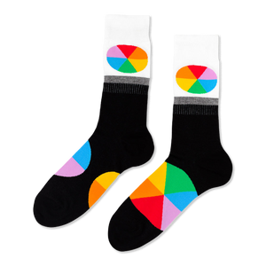 Pair of black crew socks with white cuffs. Each cuff has an oval, rainbow-segmented color wheel design. Large color wheel segments on the foot.