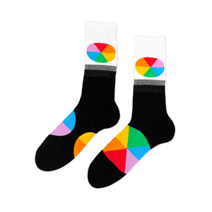 Pair of black crew socks with white cuffs. Each cuff has an oval, rainbow-segmented color wheel design. Large color wheel segments on the foot.