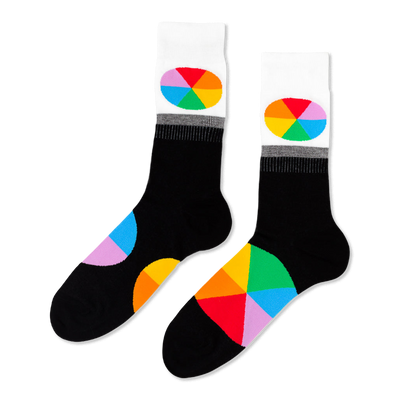 Pair of black crew socks with white cuffs. Each cuff has an oval, rainbow-segmented color wheel design. Large color wheel segments on the foot.