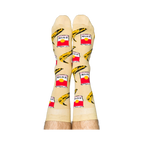 Person wearing Pop Art socks with red soup cans and yellow bananas, shown on legs from the calves down.