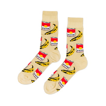 Pair of crew socks with a cream background, featuring a repeating pattern of red soup cans and yellow bananas.