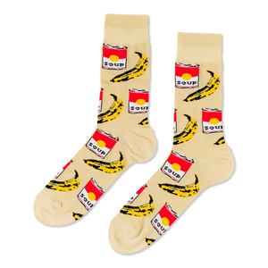 Pair of crew socks with a cream background, featuring a repeating pattern of red soup cans and yellow bananas.