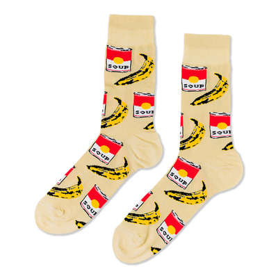 Pair of crew socks with a cream background, featuring a repeating pattern of red soup cans and yellow bananas.