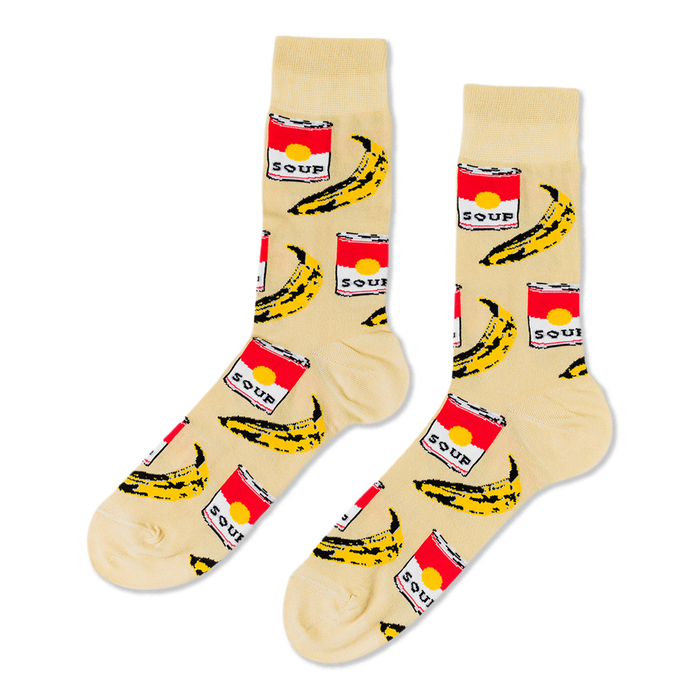 Pair of crew socks with a cream background, featuring a repeating pattern of red soup cans and yellow bananas.
