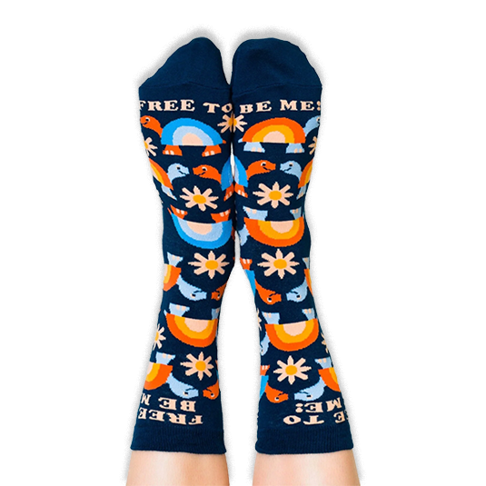 Legs wearing navy blue crew socks showing a colorful turtle and daisy pattern with text at the top and toes.