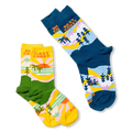 Flat lay of the yellow and green West Coast socks next to a blue and navy version of the same scenic design.