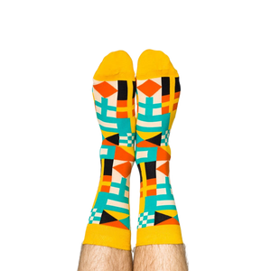 Person's legs wearing the vibrant nautical flag socks, heels up against a white background.