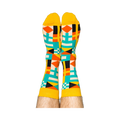 Person's legs wearing the vibrant nautical flag socks, heels up against a white background.