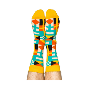 Person's legs wearing the vibrant nautical flag socks, heels up against a white background.