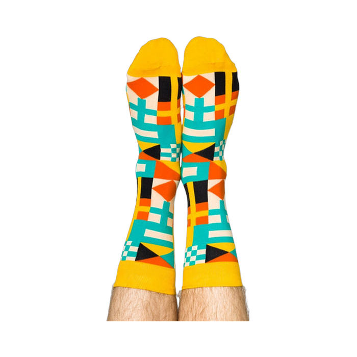 Person's legs wearing the vibrant nautical flag socks, heels up against a white background.