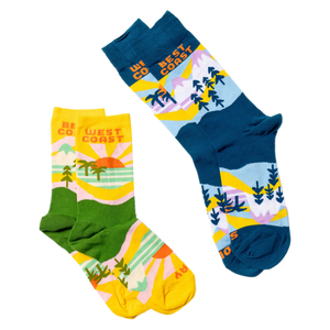 Two pairs of socks: the blue West Coast Best Coast design and a yellow and green version with similar patterns.