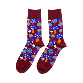 Pair of crew socks with a repeating pattern of colorful mushrooms on a dark red-brown background. Mushrooms are blue, orange, pink, white.