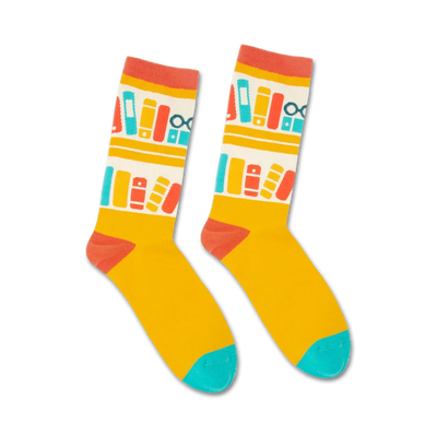 Pair of crew socks in yellow with a repeating pattern of books and glasses on a bookshelf in red, teal, and white.