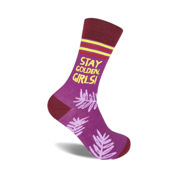 purple crew socks with dark red cuff, yellow toe, and yellow "stay golden girls!" lettering on front and pink palm leaf pattern on back.  