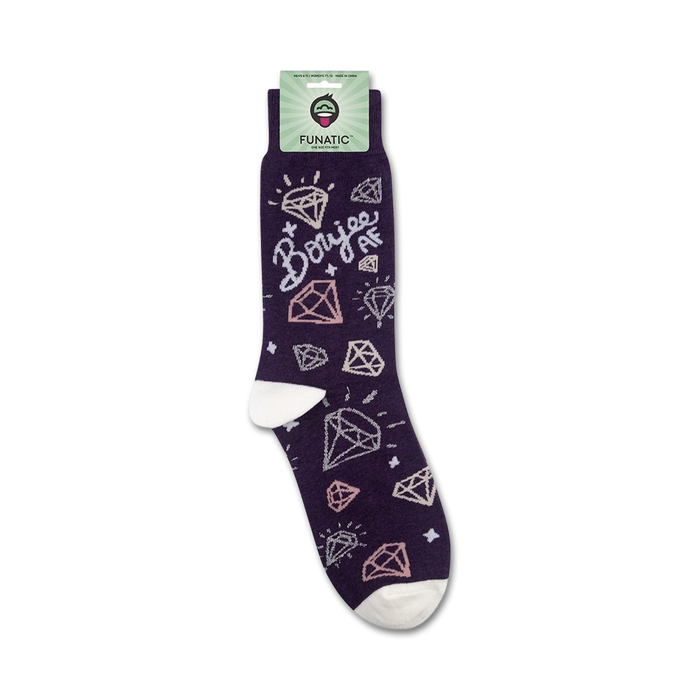 A pair of purple socks with white toes and heels. The socks have a repeating pattern of pink and white diamonds with the word 